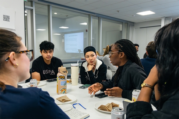 Engineering Sciences major Maanat Bhadani '29 (left), discussed ideas with a group, including Geisel School of Medicine master's student Bilqis Omoyeni Ayeni, MED'29 (right).
