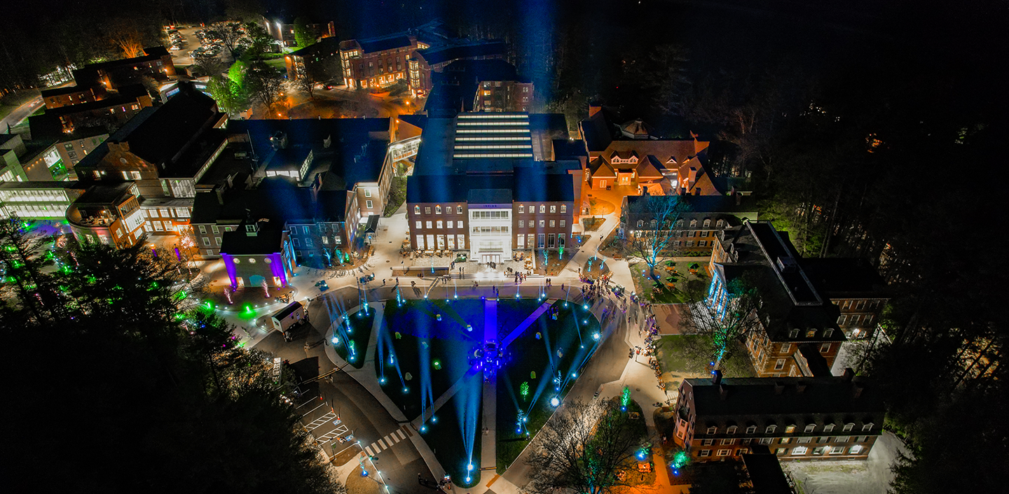 An image of Dartmouth's West End District buildings lit up by colorful lights at night