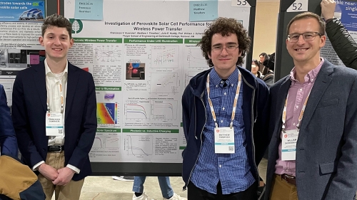 A group of people stand in front of an academic poster with text and graphics.