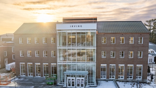 The Irving Institute building on a snowy early spring evening with the sun setting behind the building 