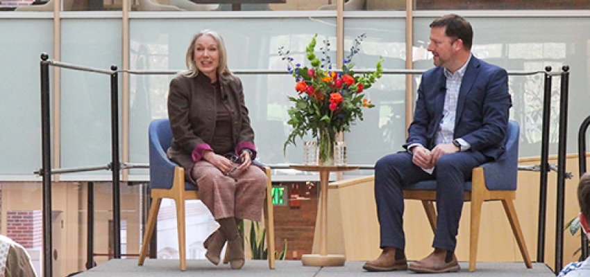 Miranda Ballentine and Derek Walker on a small stage in the Irving Institute Atrium.