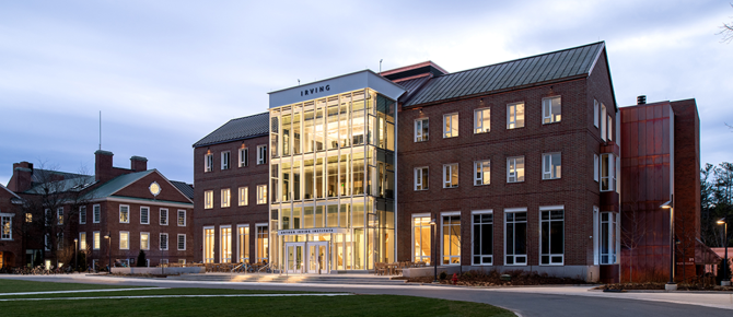 An image of the Irving Institute building in early evening with its windows and entrance glowing