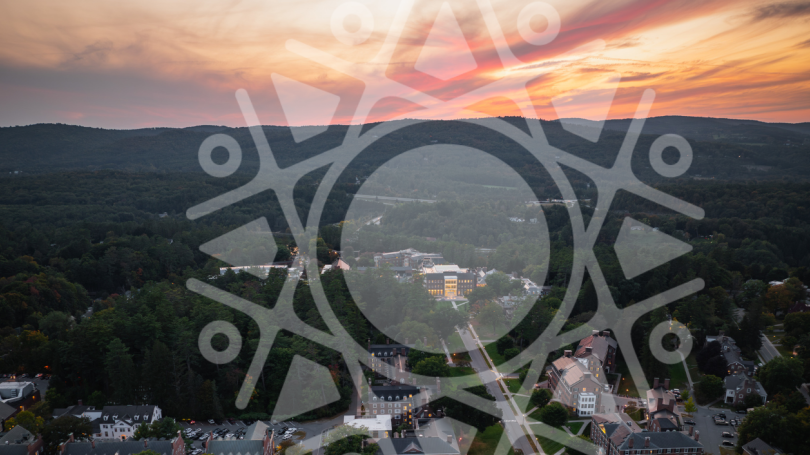an aerial view of Dartmouth's West End at sunset with faint Irving Institute "sunburst" brandmark superimposed over the image