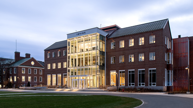 An image of the Irving Institute building in early evening with its windows and entrance glowing