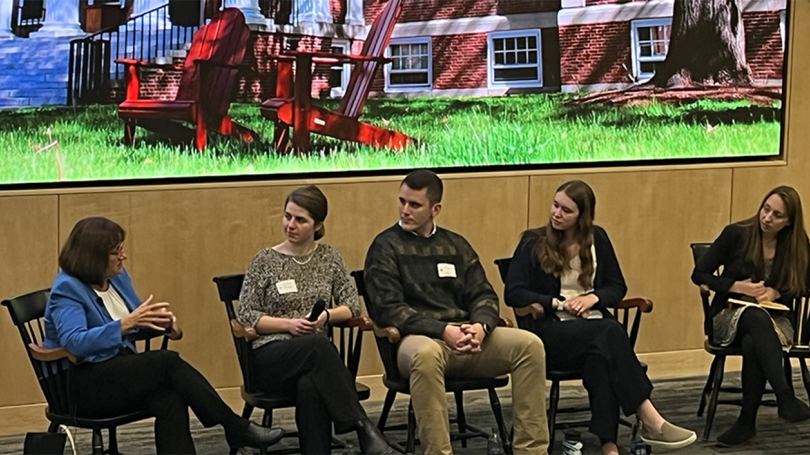 a panel of people sitting in chairs on a stage