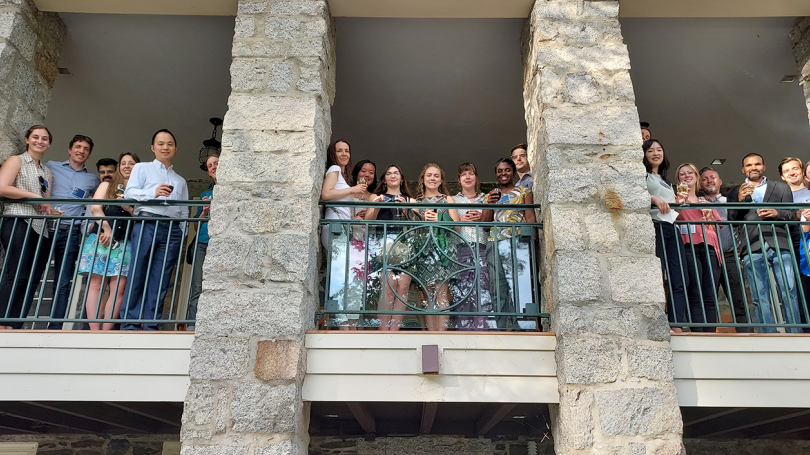 A photo looking up at a group standing on a stone balcony