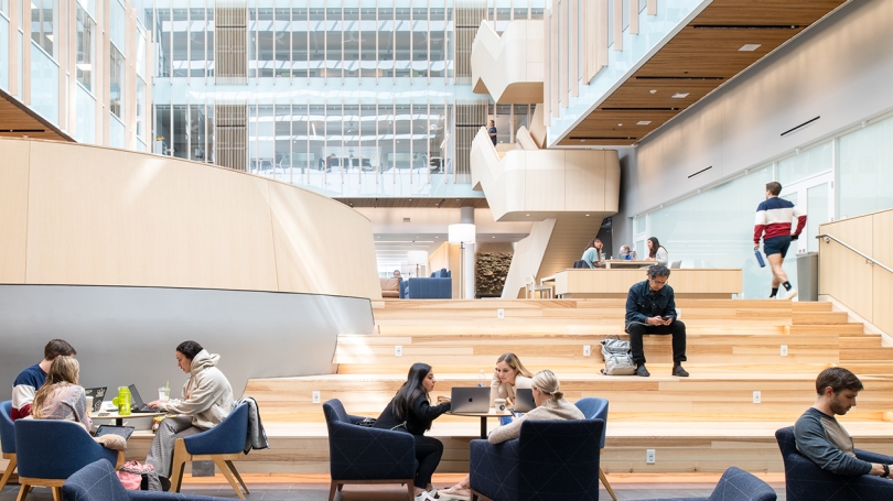 Groups of students sit and read or study together in the Irving Institute Atrium.