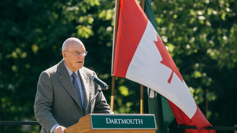 Arthur Irving at a podium that says Dartmouth and a Canadian flag behind him