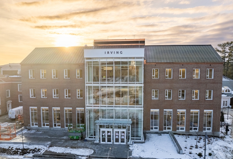 The Irving Institute building on a snowy early spring evening with the sun setting behind the building