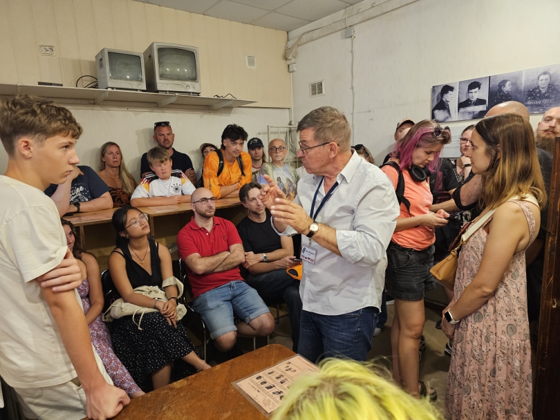 A group of students listen to a man 