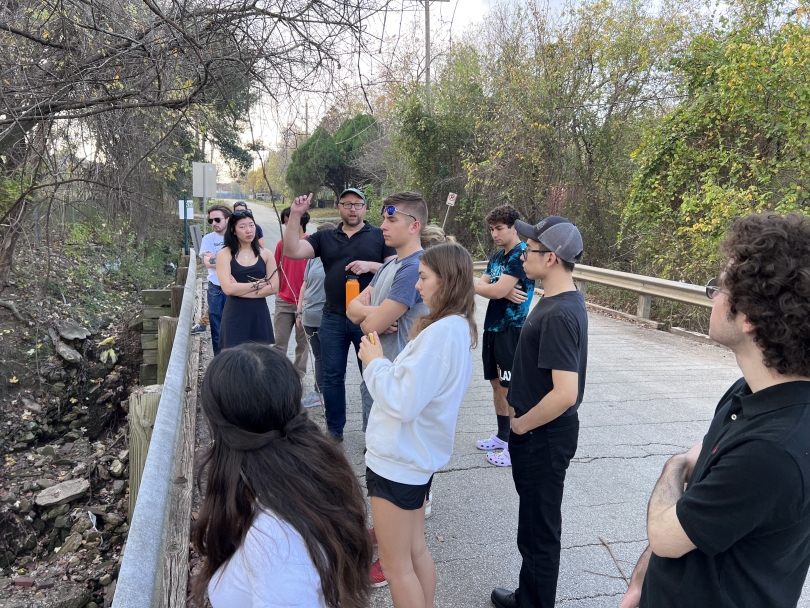 students standing on a bridge in a natural area
