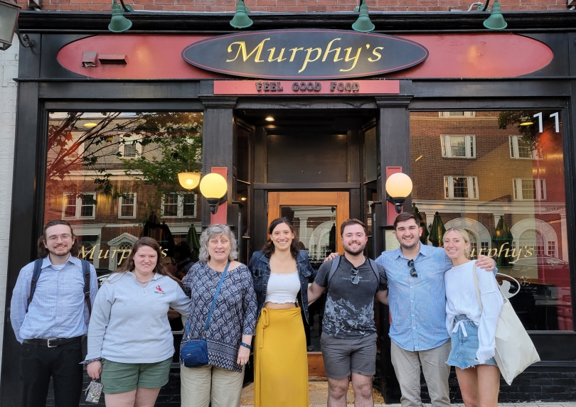 A group of people in front of a restaurant posing for a picture