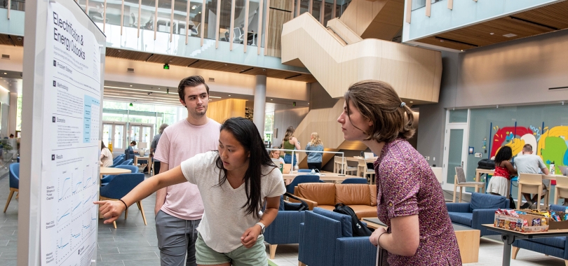 Students look at a poster in the Irving Institute Atrium.