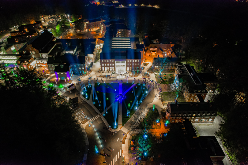An aerial view of the Irving Institute, Tuck School, and Thayer School at night bathed in colorful lights