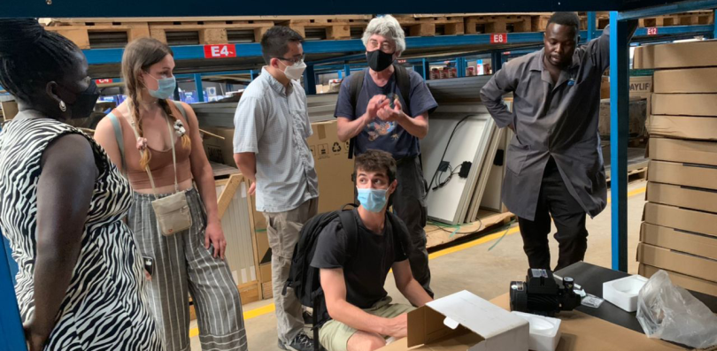 A group of people some who are wearing masks examining items in a warehouse