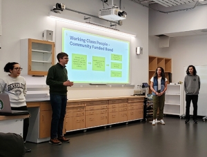 Dartmouth students deliver a presentation at EnergyHack 2025. Dartmouth students deliver a presentation in front of a projector screen.
