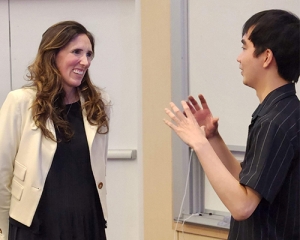 Two people stand and talk with each other.